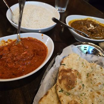 Moksha Indian Grill - Clockwise from top left: Basmati Rice ($4), Goat Curry ($22), Garlic Naan ($5), Butter Chicken ($19) - Indian Near Me - Northbrook, Illinois Moksha Indian Grill - Clockwise from top left: Basmati Rice ($4), Goat Curry ($22), Garlic Naan ($5), Butter Chicken ($19) - Indian Near Me - Northbrook, Illinois