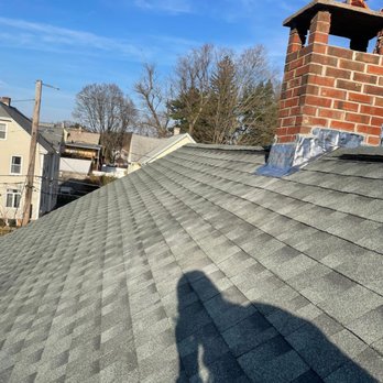 Rain Day Roofing - a shadow of a person on a roof - Roofing Near Me