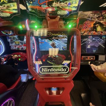 Ka-Ko Jo's - A Nintendo arcade racing game machine featuring a screen with a racing game and a red seat, located in an arcade setting. - Arcades Near Me - Aurora, Colorado