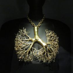Friends Of The V & A - A decorative gold branch hanging loosely on the neck of a model.