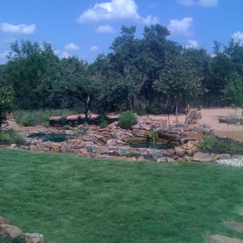 Aqua Systems Inc - a pond in a backyard - Electricians Near Me - Austin, Texas
