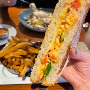 Reds - a person holding a sandwich over a plate of french fries - Venues & Event Spaces Near Me - Mississauga, Ontario Reds - a person holding a sandwich over a plate of french fries - Venues & Event Spaces Near Me - Mississauga, Ontario