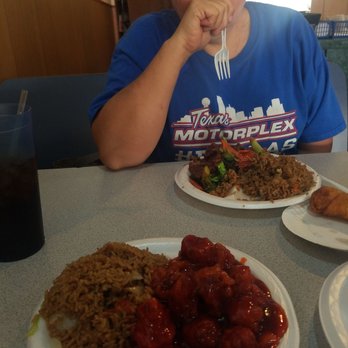 New China - a woman sitting at a table with plates of food - Chinese Near Me - Windsor, Missouri
