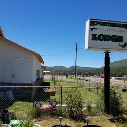 Sportsman's Lodge - Sign above dog area and highway with elk close by