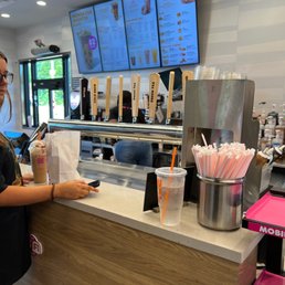 a woman standing at the counter of a dunkin donuts shop a woman standing at the counter of a dunkin donuts shop