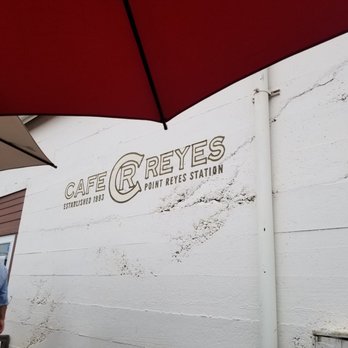 Cafe Reyes - a man standing under an umbrella - Pizza Near Me - Point Reyes Station, California