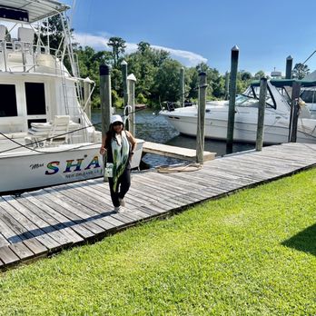 Nathan's Restaurant - a woman walking on a dock with boats in the background - Cajun/Creole Near Me - Slidell, Louisiana