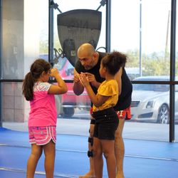 No Surrender Athletics - Coach Javier explaining technique to two Muay Thai Students