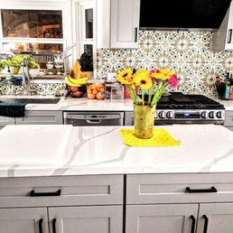 a kitchen island with a vase of flowers on it