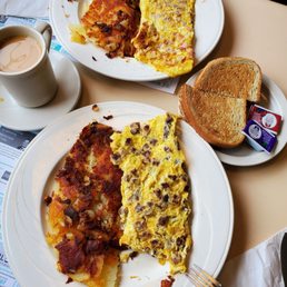 Two omelets with home fries, rye toast and coffee