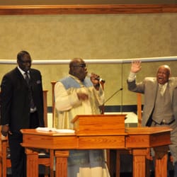 Bishop Johnson preaching under the anointing with a praise coming from one of the elders of the church.