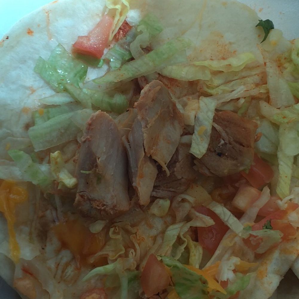 Three tiny piece of chicken on a giant flour tortilla. Three tiny piece of chicken on a giant flour tortilla.