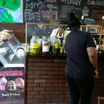 Super Hero Subs - a woman standing in front of a counter - Sandwiches Near Me - Jersey City, New Jersey Super Hero Subs - a woman standing in front of a counter - Sandwiches Near Me - Jersey City, New Jersey