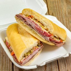 Randall's Curbside Griddle - Muffuletta sandwich with Swiss, ham, pastrami, salami, and provolone topped with an olive salad on fresh baked Cuban bread