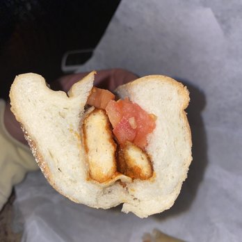 Pizza Academy - a hand holding a half eaten sandwich - Pizza Near Me - Exeter, New Hampshire