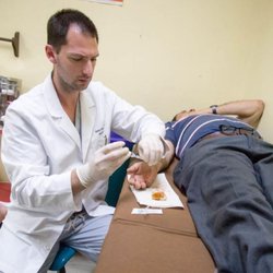 Orrin Franko, MD - East Bay Hand Medical Ctr - Honduras medical mission - performing a bedside procedure