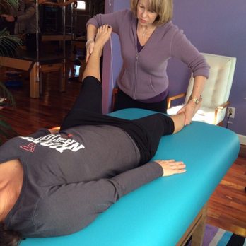 The Pilates Center - Owner,Mary-Jane Amrein is helping a client with leg muscular pain using Muscle Activation Techniques - Pilates Near Me - Williamsburg, Virginia