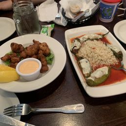 Gator Nuggets - A meal featuring fried chicken wings with a dipping sauce and stuffed peppers topped with cheese and rice, served on a white rectangular dish.