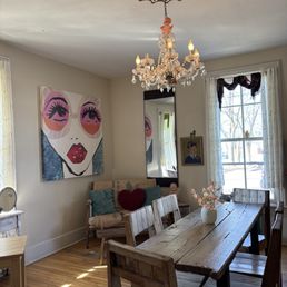 Sun-filled parlor w a timeless chandelier.