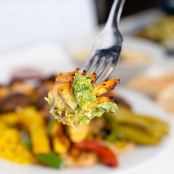 Niles Authentic Mediterranean Grill - a fork holding a piece of broccoli - Halal Near Me - Chicago, Illinois Niles Authentic Mediterranean Grill - a fork holding a piece of broccoli - Halal Near Me - Chicago, Illinois