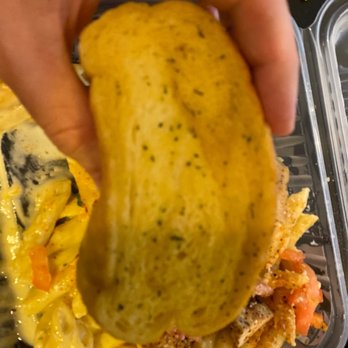 Chili's - a hand holding a piece of food - American Near Me - Weatherford, Texas Chili's - a hand holding a piece of food - American Near Me - Weatherford, Texas