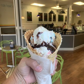 Main Scoop Creamery - 2 scoops of Manasquan Munchies with hot fudge topping in a waffle cone - Ice Cream & Frozen Yogurt Near Me - Manasquan, New Jersey Main Scoop Creamery - 2 scoops of Manasquan Munchies with hot fudge topping in a waffle cone - Ice Cream & Frozen Yogurt Near Me - Manasquan, New Jersey