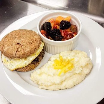 Cordell's - Sausage, egg, and cheese biscuit with cheesy garlic grits and a peach balsalmic glazed fruit salad. - New American Near Me - Abilene, Texas