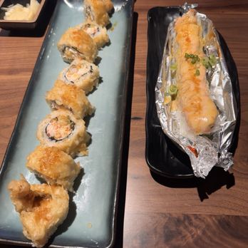 Sushi Tsunami - Golden gate on the left. On the right, it's the lion king. Baked Salmon on top along with a cheese sauce on top of the salmon. - Sushi Bars Near Me - Fairfield, California