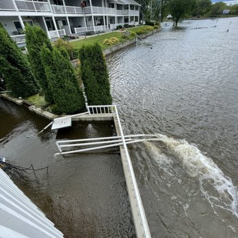 Slippery's - Bar under water - Flooding has caused water to overflow into a residential complex's outdoor area, submerging a patio and damaging fencing. - American Near Me - Wabasha, Minnesota