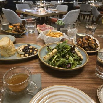 Trademark - Shared plate feast! Southern greens salad, Baked brie,prosciutto and fig flatbread, and chargrilled wings. - American Near Me - Alexandria, Virginia