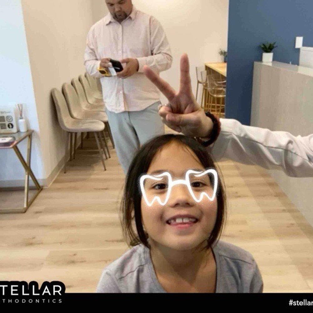 Stellar Orthodontics - Joy's funny glasses with Dr. Stella making bunny ears...and me in the background finishing some digital forms from her visit. - Orthodontists Near Me - Gilbert, Arizona Stellar Orthodontics - Joy's funny glasses with Dr. Stella making bunny ears...and me in the background finishing some digital forms from her visit. - Orthodontists Near Me - Gilbert, Arizona