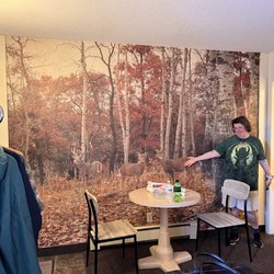 Motel Ely - A small sitting area with a woodland wallpaper scene.