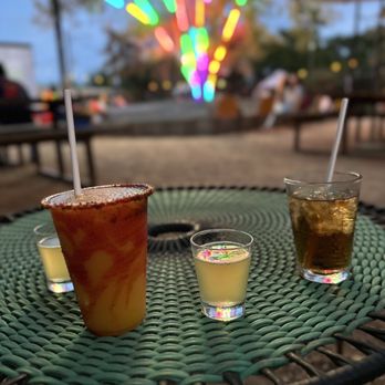 Axelrad - three drinks on a table in front of a colorful tree - Beer Gardens Near Me - Houston, Texas Axelrad - three drinks on a table in front of a colorful tree - Beer Gardens Near Me - Houston, Texas