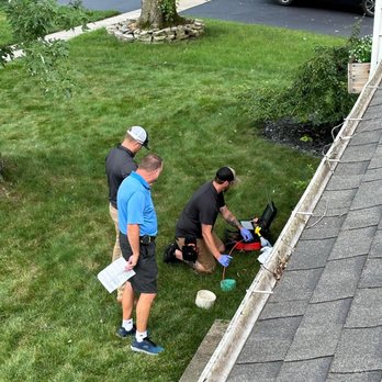 Insideout Inspections - High-angle view of three home inspectors using portable camera equipment to conduct a sewer scope inspection on a lawn. - Home Inspectors Near Me - Ottawa Lake, Michigan Insideout Inspections - High-angle view of three home inspectors using portable camera equipment to conduct a sewer scope inspection on a lawn. - Home Inspectors Near Me - Ottawa Lake, Michigan
