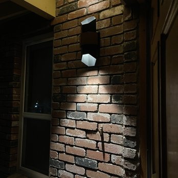 S&E Electric - New outdoor lighting installed. - A contemporary outdoor wall light is attached to a brick wall, illuminating the brick surface at night. - Electricians Near Me - Auburn, California
