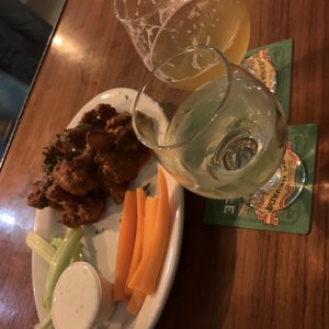 Photo of Lost & Found Beer Garden - Oakland, CA, United States. Spicy buffalo cauliflower wings with book of palms beer and sparkling white wine