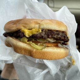 a hand holding a hamburger a hand holding a hamburger