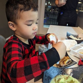 Umai Revolving Sushi - Enjoying his selection - Sushi Bars Near Me - Rochester, New York Umai Revolving Sushi - Enjoying his selection - Sushi Bars Near Me - Rochester, New York