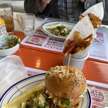 LTBURGER WEST - a man eating a burger with bacon and lettuce - Burgers Near Me - Westhampton Beach, New York