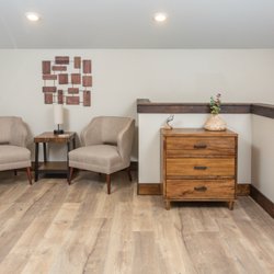 Alaska Backcountry Cottages - Pine Upstairs bedroom Sitting area, two chairs, a table,lamp with USB ports for charging devices