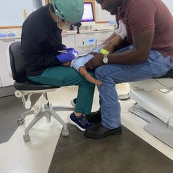 Greater Houston Pediatric Dentistry - My son being held by my husband and the dental assistant while she looks at his teeth