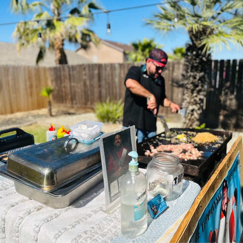 Nor-BQ - a man preparing food on a grill - Caterers Near Me