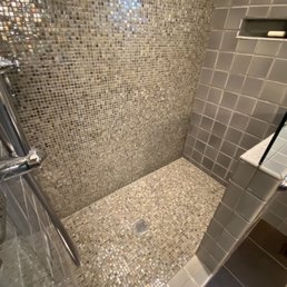 2008 bathroom, after repair.  12"x12" careful demo & re-tile done between square drain and tiled back wall.