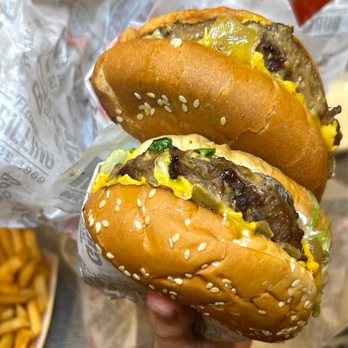 Habit Burger & Grill - a hand holding two hamburgers - Burgers Near Me - Irvine, California Habit Burger & Grill - a hand holding two hamburgers - Burgers Near Me - Irvine, California