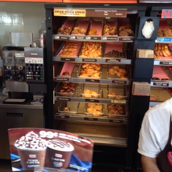 Dunkin' -  a man standing in front of a display of donuts - Donuts Near Me - Drexel Hill, Pennsylvania