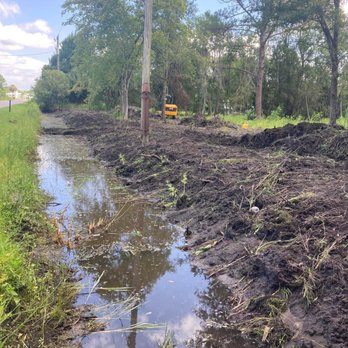 Above The Standard - a muddy road with a puddle of water - Tree Services Near Me - Palatka, Florida Above The Standard - a muddy road with a puddle of water - Tree Services Near Me - Palatka, Florida