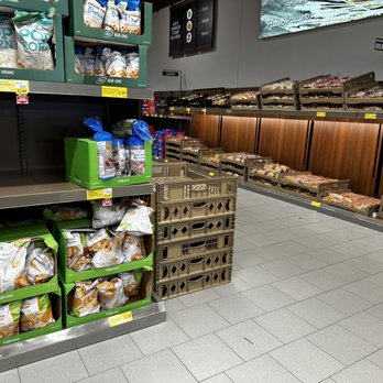 ALDI - a grocery store with a variety of goods - Grocery store aisle with mostly empty shelves, including snack and frozen food sections, with some products and crates remaining. - Grocery Near Me - Roseville, Michigan