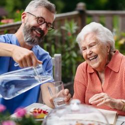 Cape Senior Home Healthcare - A caregiver assisting a senior woman during mealtime, highlighting Cape Senior Home Health Care's personalized support with d...
