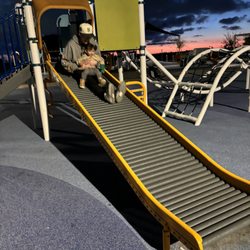 An adult and a child going down a slide