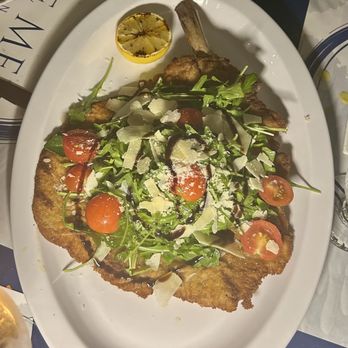 The Med - Veal chop Milanese with arugula, tomatoes and shaved parm - Mediterranean Near Me - Naples, Florida The Med - Veal chop Milanese with arugula, tomatoes and shaved parm - Mediterranean Near Me - Naples, Florida